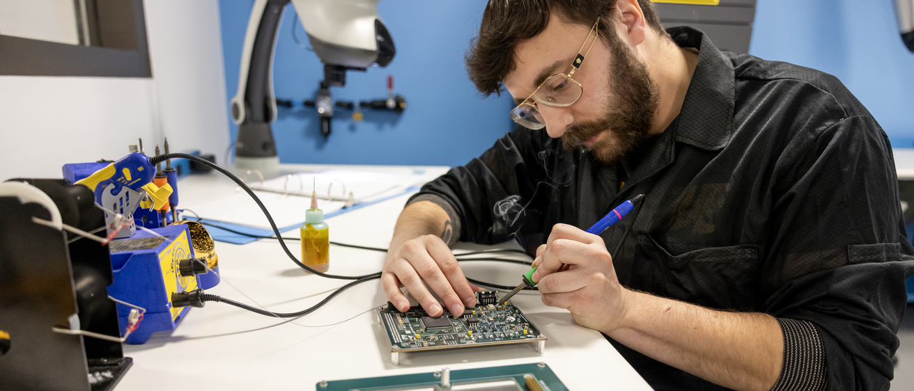 Samuel Hisel working on a circuit board in the Iowa Spaceflight Laboratory