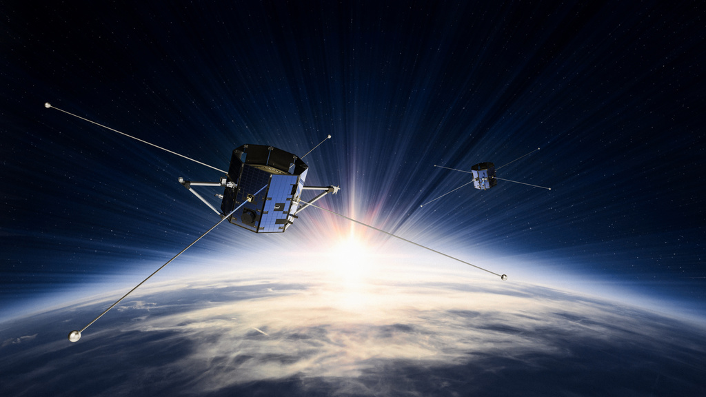 A rendered image of the two TRACERS satellites in orbit above Earth, highlighted by the sun beginning to shine from behind Earth