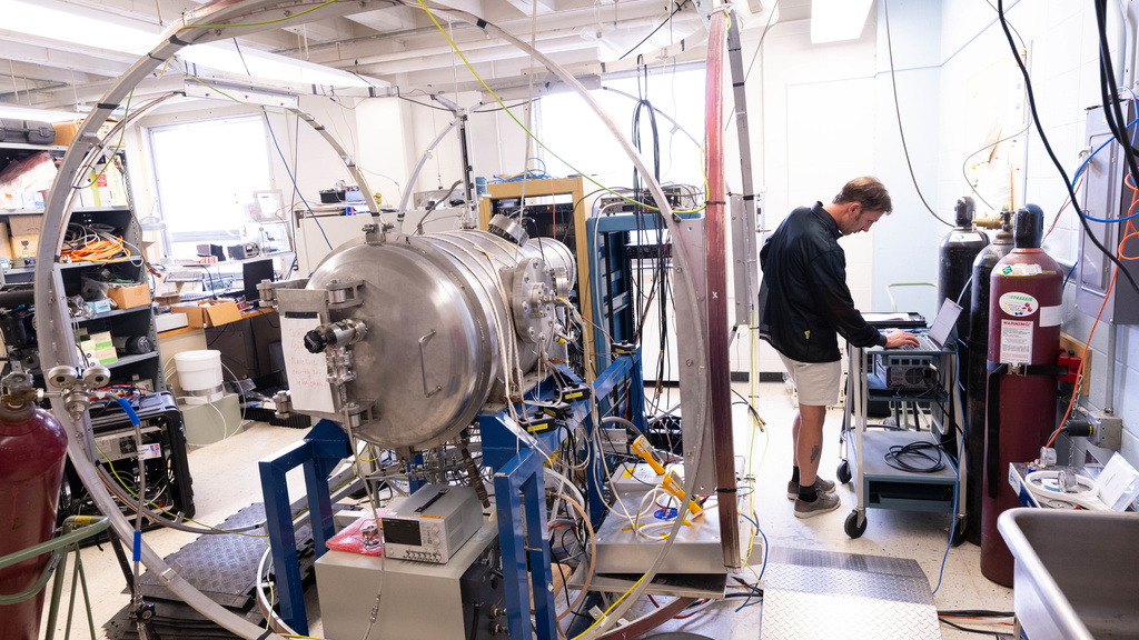 Professor Jasper Halekas stands in a lab, checking a computer hooked up to a thermal chamber