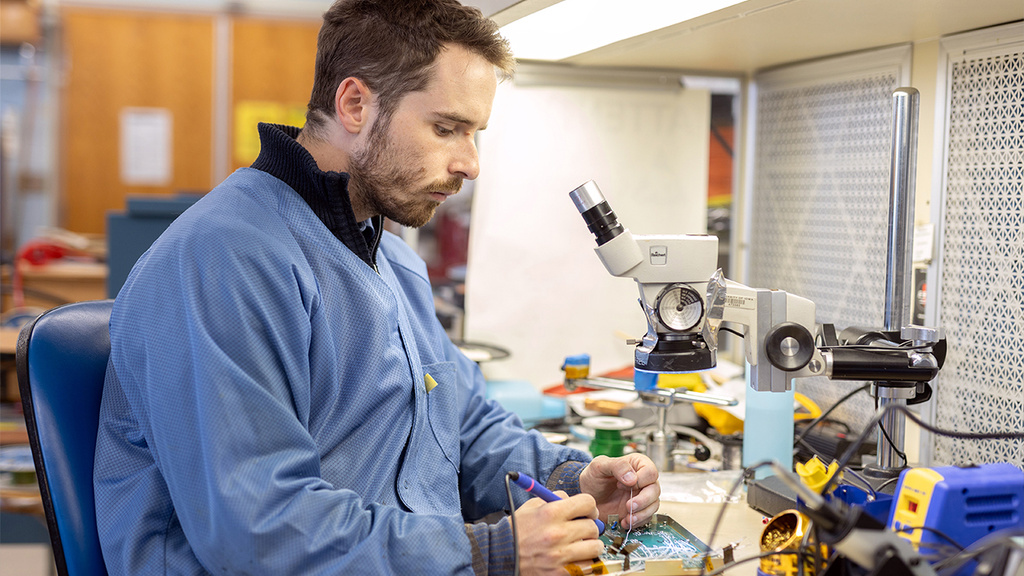 A photo of a student soldering electronics in a lab at Iowa